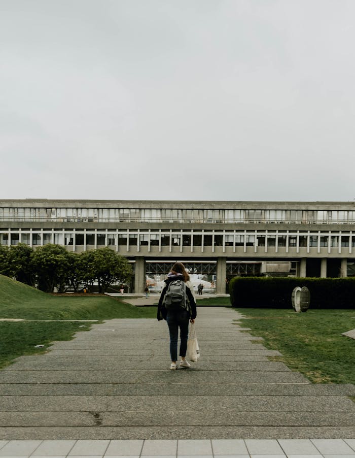 journey A woman with a backpack walking on Simon Fraser University campus, Burnaby, Canada.